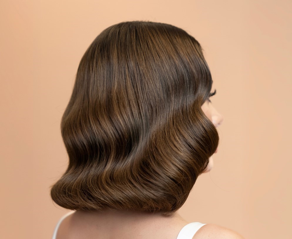 Professional stylist-created wavy hair and flawless makeup on woman from behind