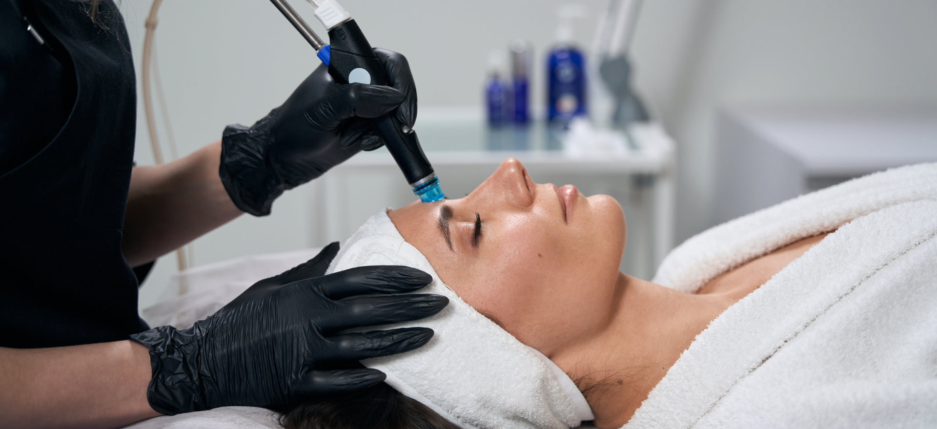 Esthetician performing HydraFacial treatment on client's face