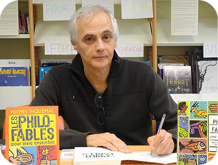 Michel Piquemal à son bureau avec son livre Les Philo-Fables.