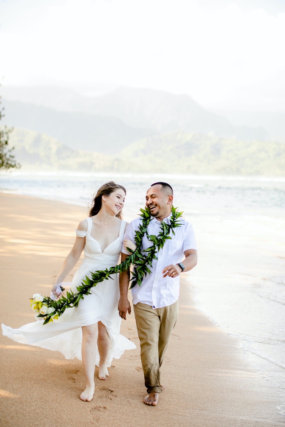 Couple walking on a beCh in Kauai.