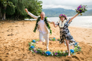 Chrissie & Al jumping out of a flower circle on the beach in Kauai.