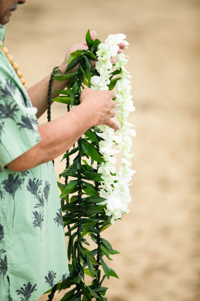 Man Holding Lei on the beach in Hawaii.