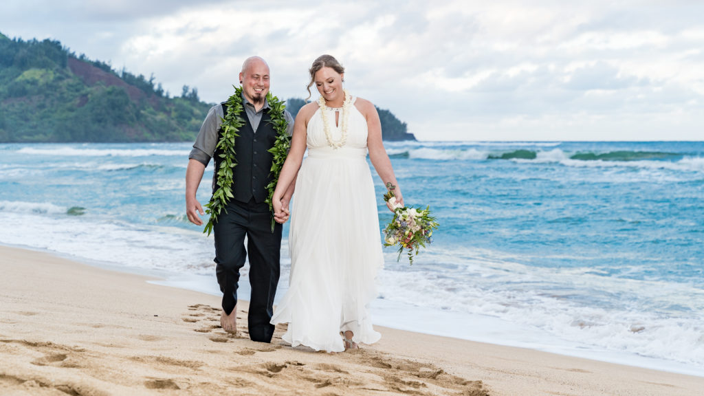 Bride and Groom walking on a beach in Kauai.