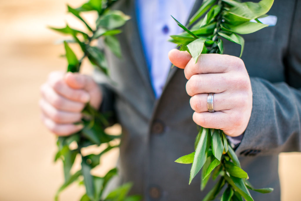 Groom wearing lei.