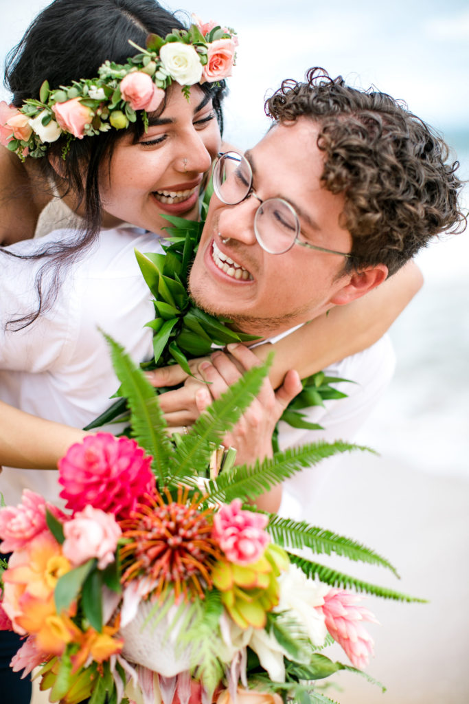 Bride and Groom being playful on the beach in Kauai.