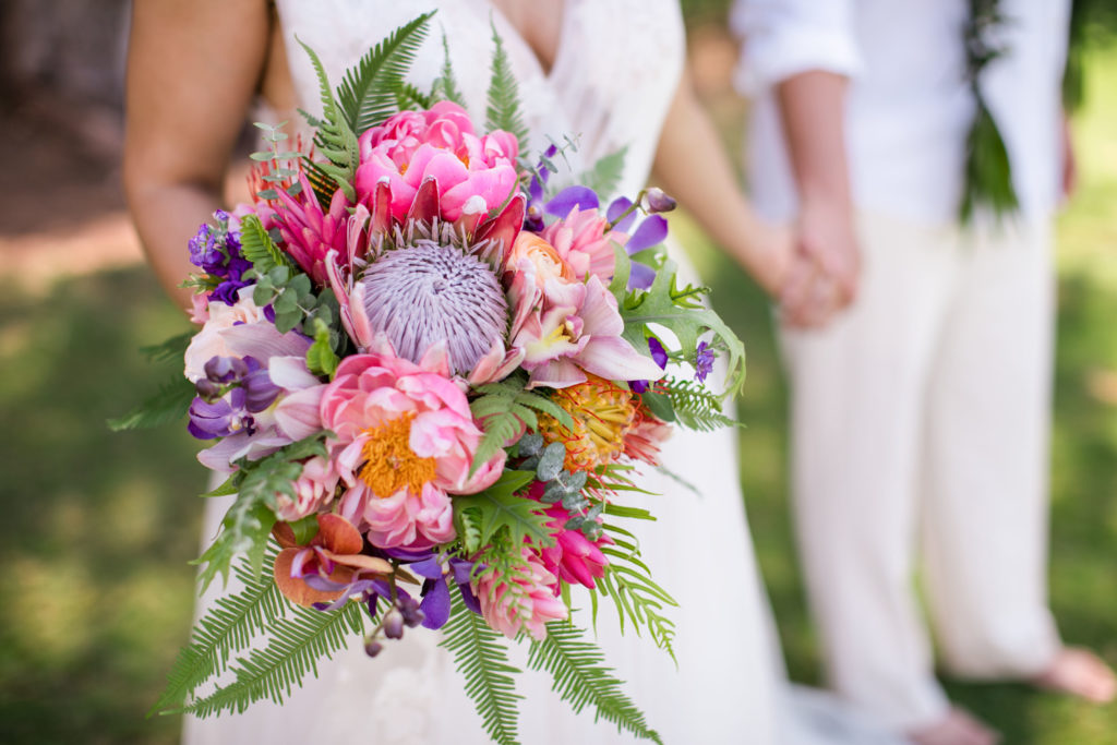 Bride holding floral arrangement.