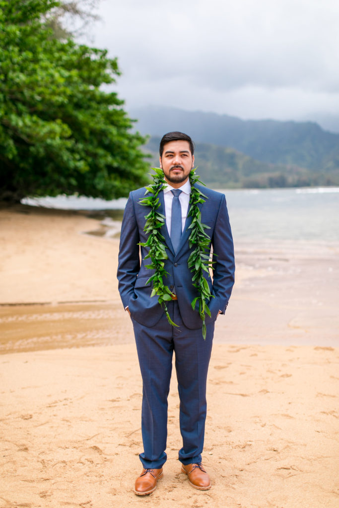 Groom on the beach wearing a Lei.