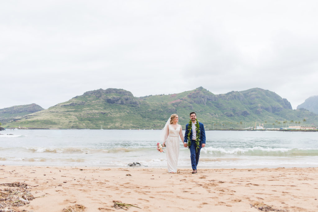 Bride and groom walking on the beach.
