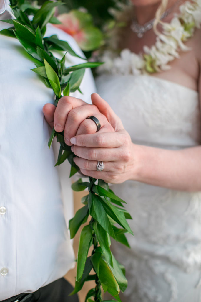 Closeup of wedding rings on husband and wife. 