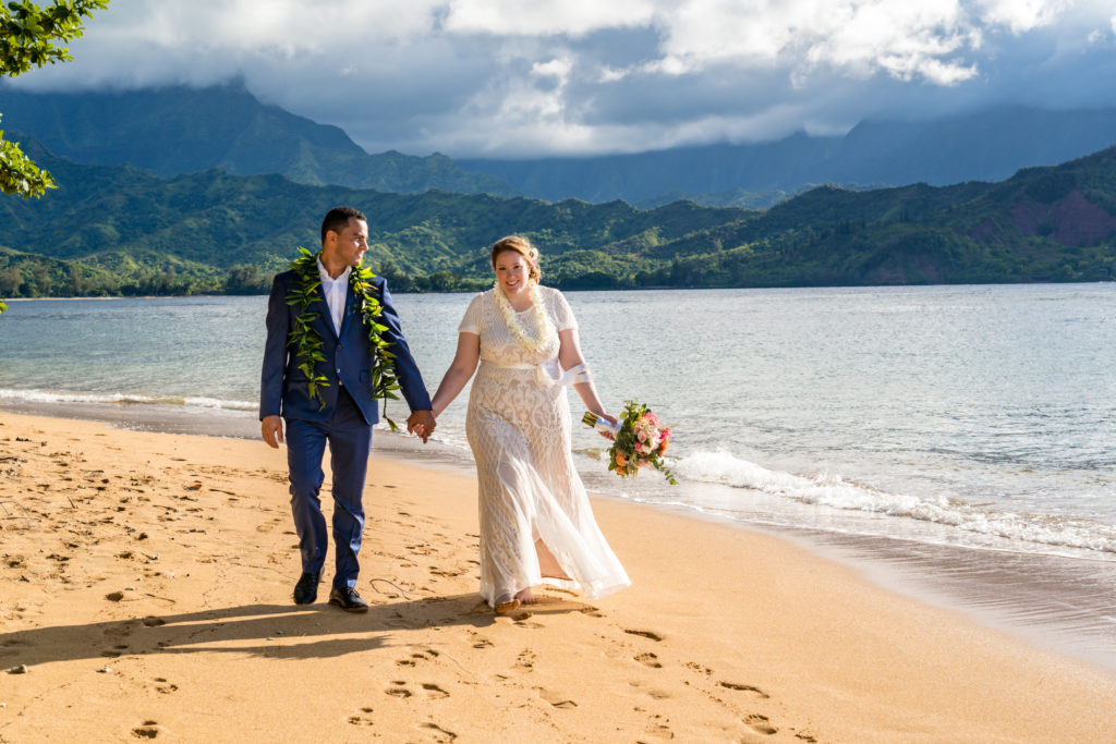 Bride and groom walking on the beach.