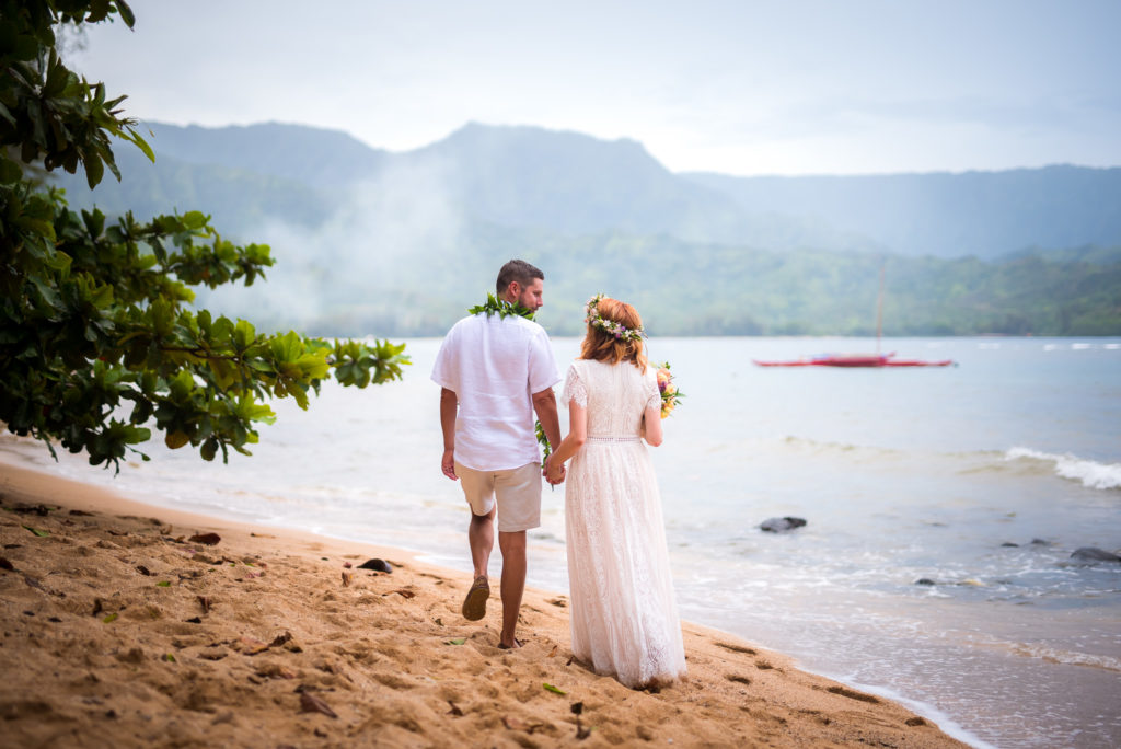 Bride and groom walking on the beach.