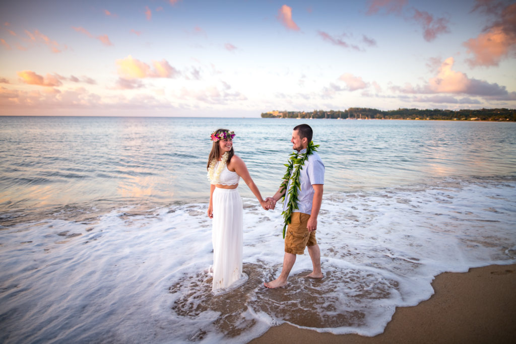 Bride and groom walking on the beach.
