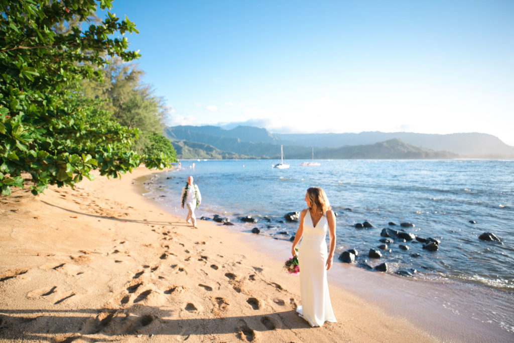 Bride and groom walking on the beach.