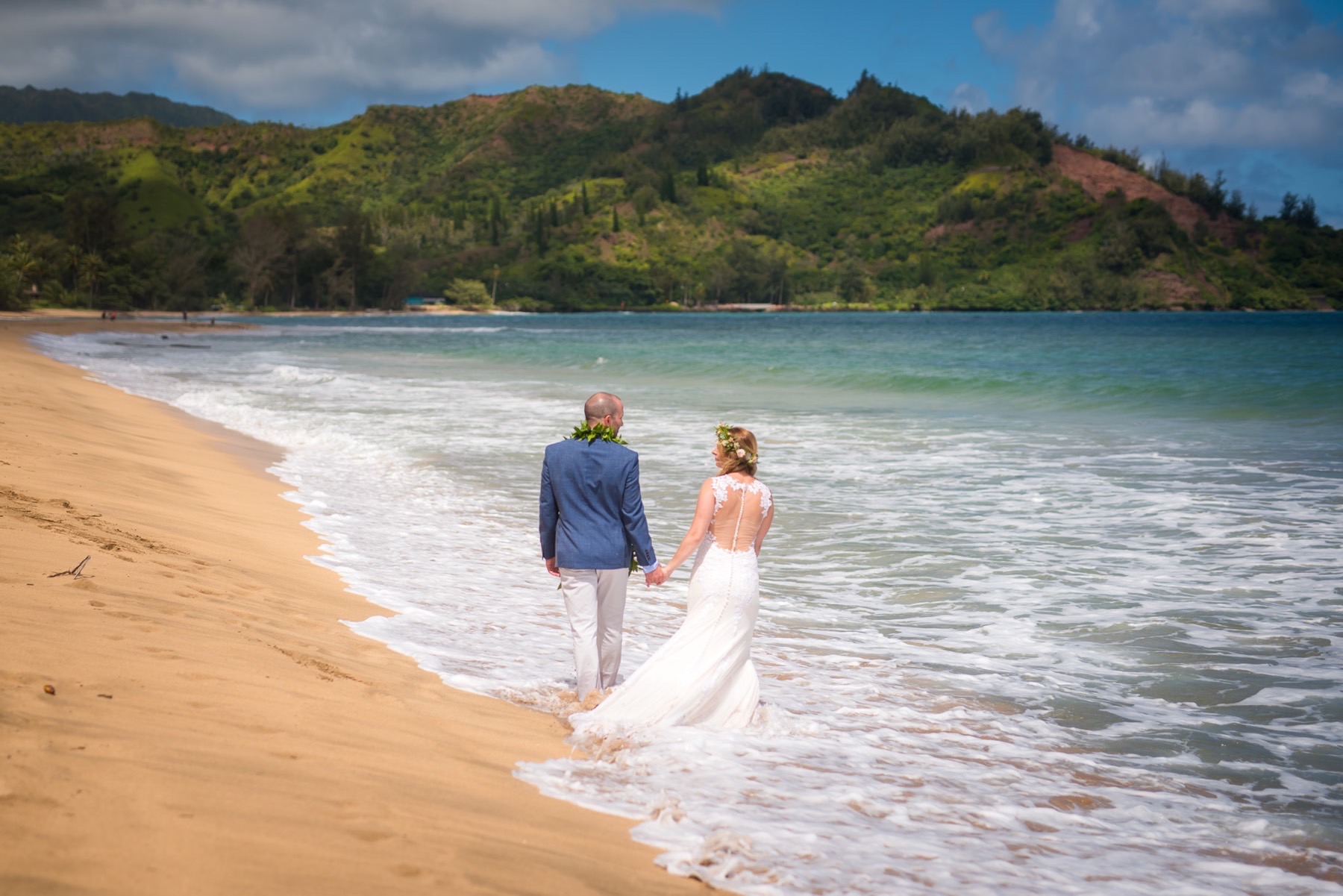 Bride and groom walking on the beach.