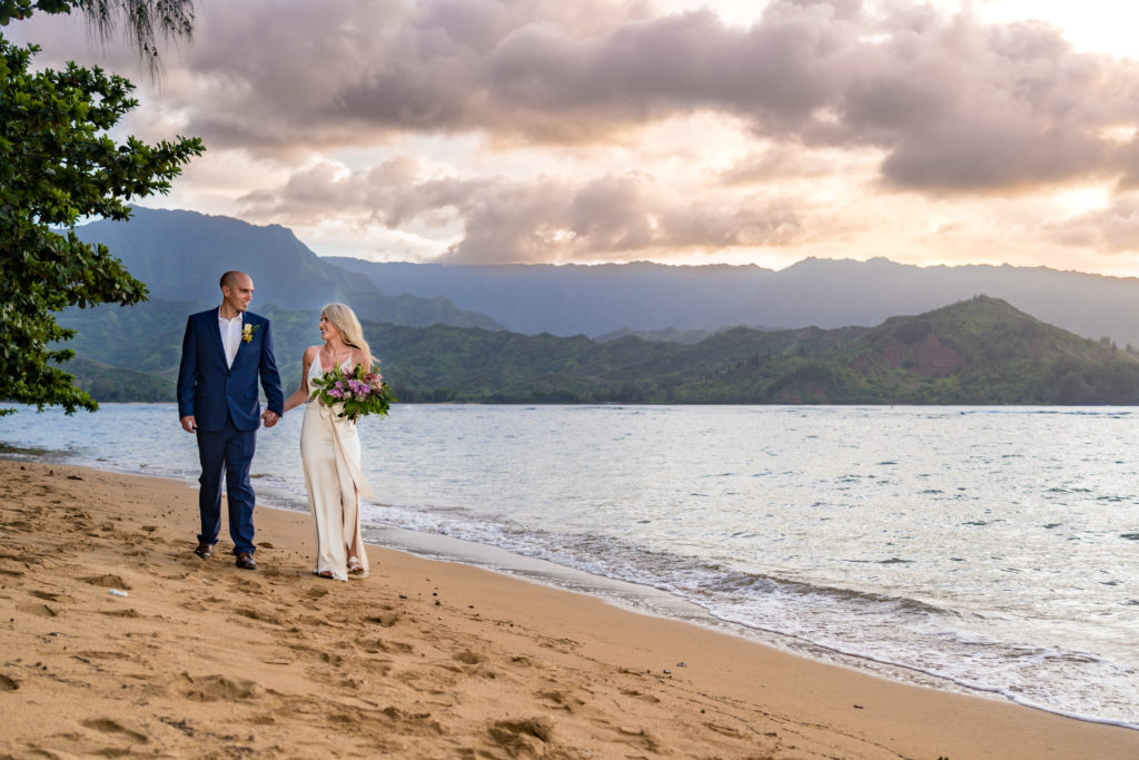 Bride and groom walking on the beach in Kauai.