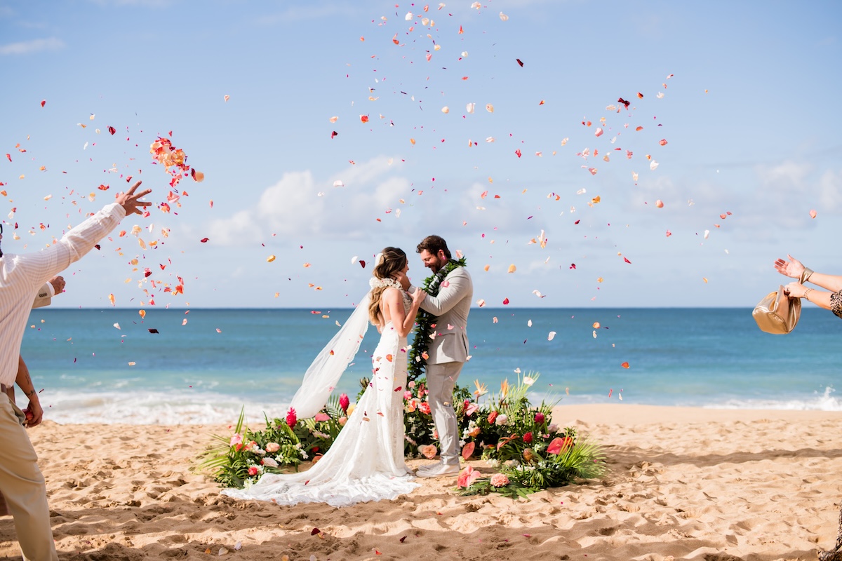 Couple standing in a floral ceremony circle at Tunnels beach