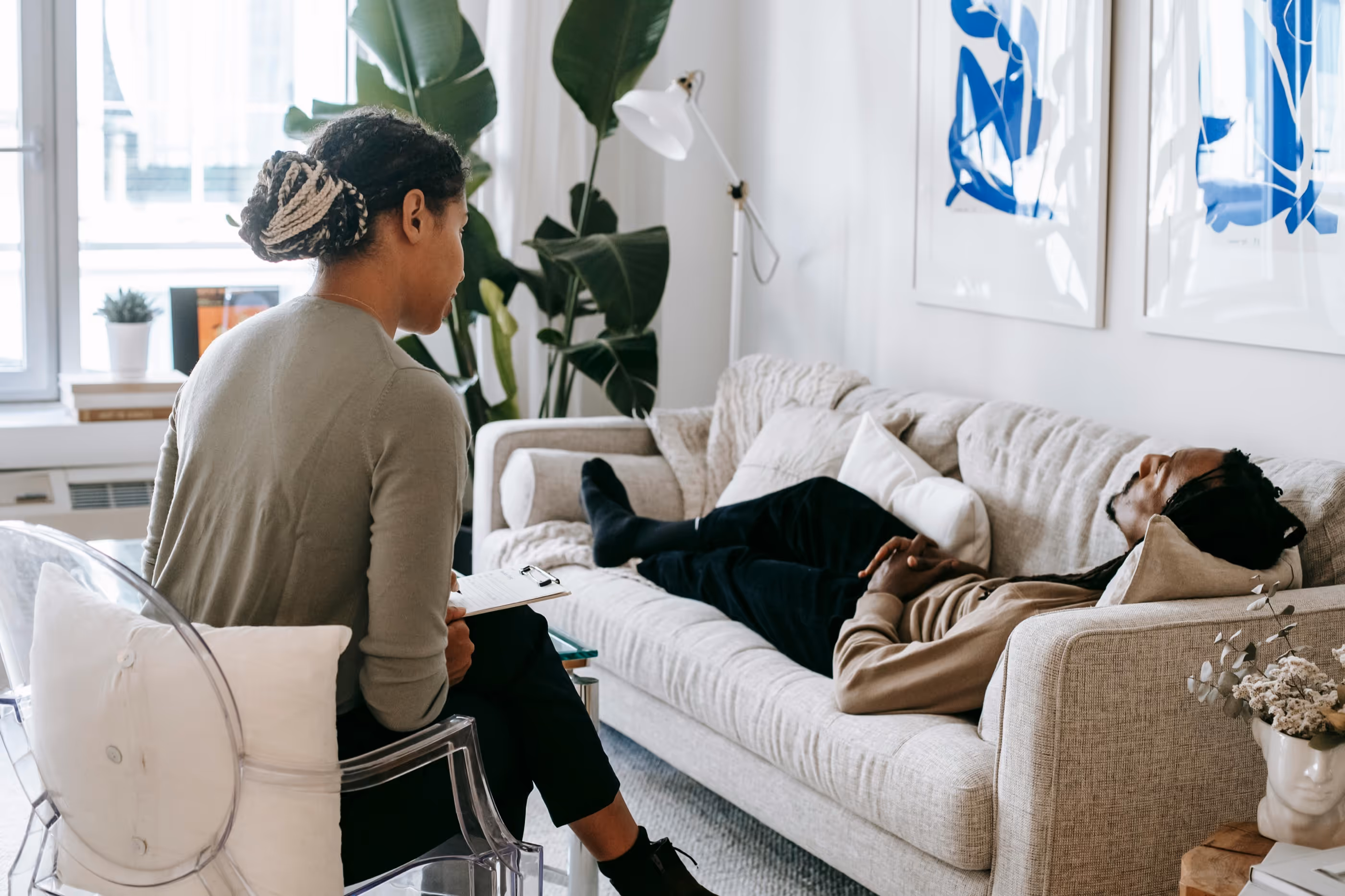 Team collaborating around a table with a notebook showing diagrams and colorful paper shapes.