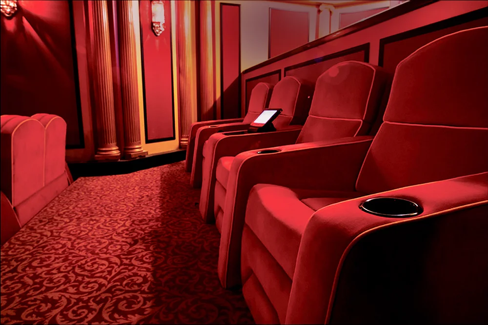 Luxury cinema-style theater seating with red upholstered recliners in a private screening room by Elite HTS