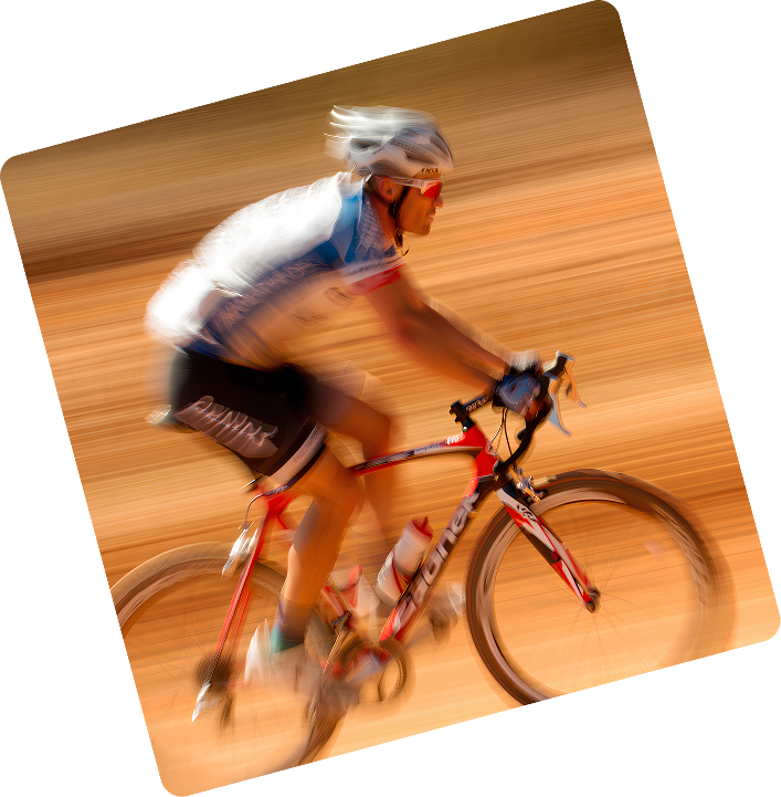 Cyclist wearing a white helmet and sunglasses riding a red bicycle, motion blur effect.