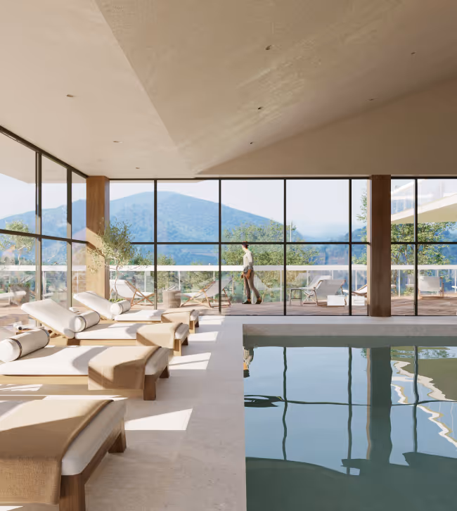 Indoor pool area with beige lounge chairs beside a large glass wall overlooking mountains and a person walking outside on the terrace.