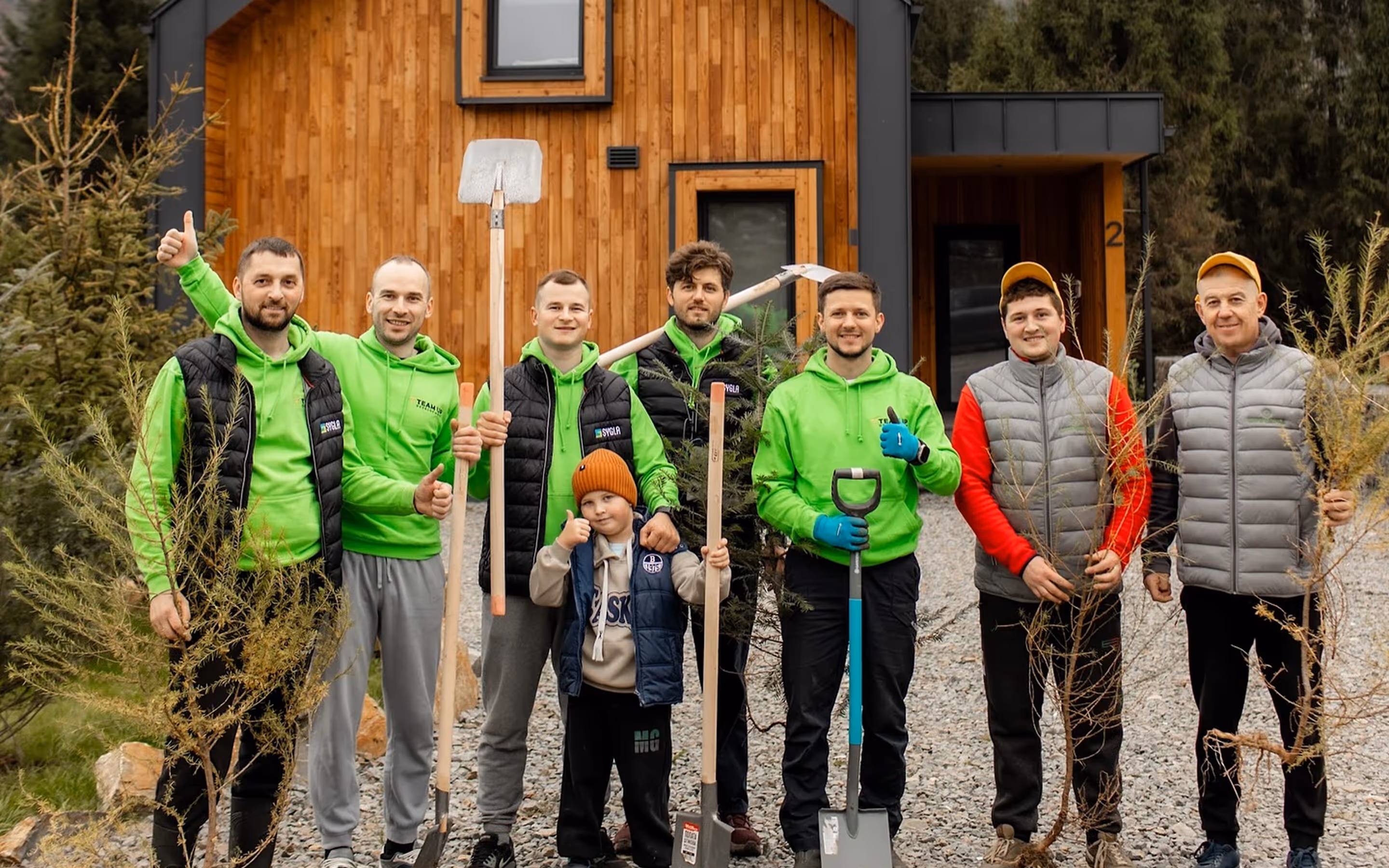 Indoor pool area with beige lounge chairs beside a large glass wall overlooking mountains and a person walking outside on the terrace.