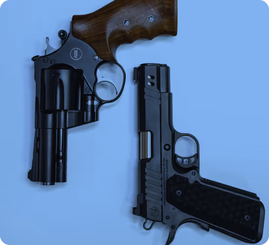 Black revolver with wooden grip beside a black semi-automatic pistol on a blue background.