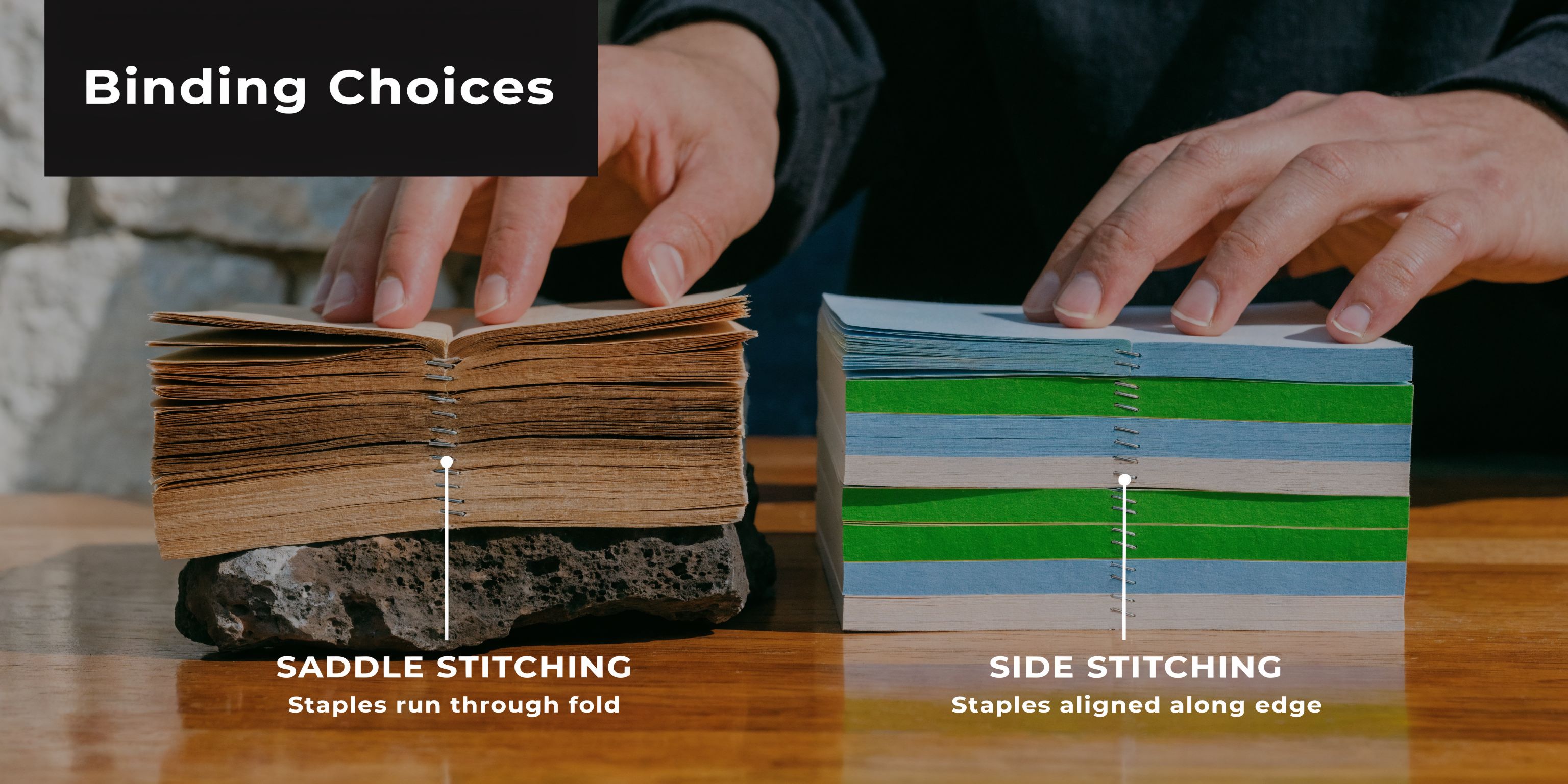 Two hands resting on two different notebook examples showing saddle stitching and side stitching binding methods with staples.