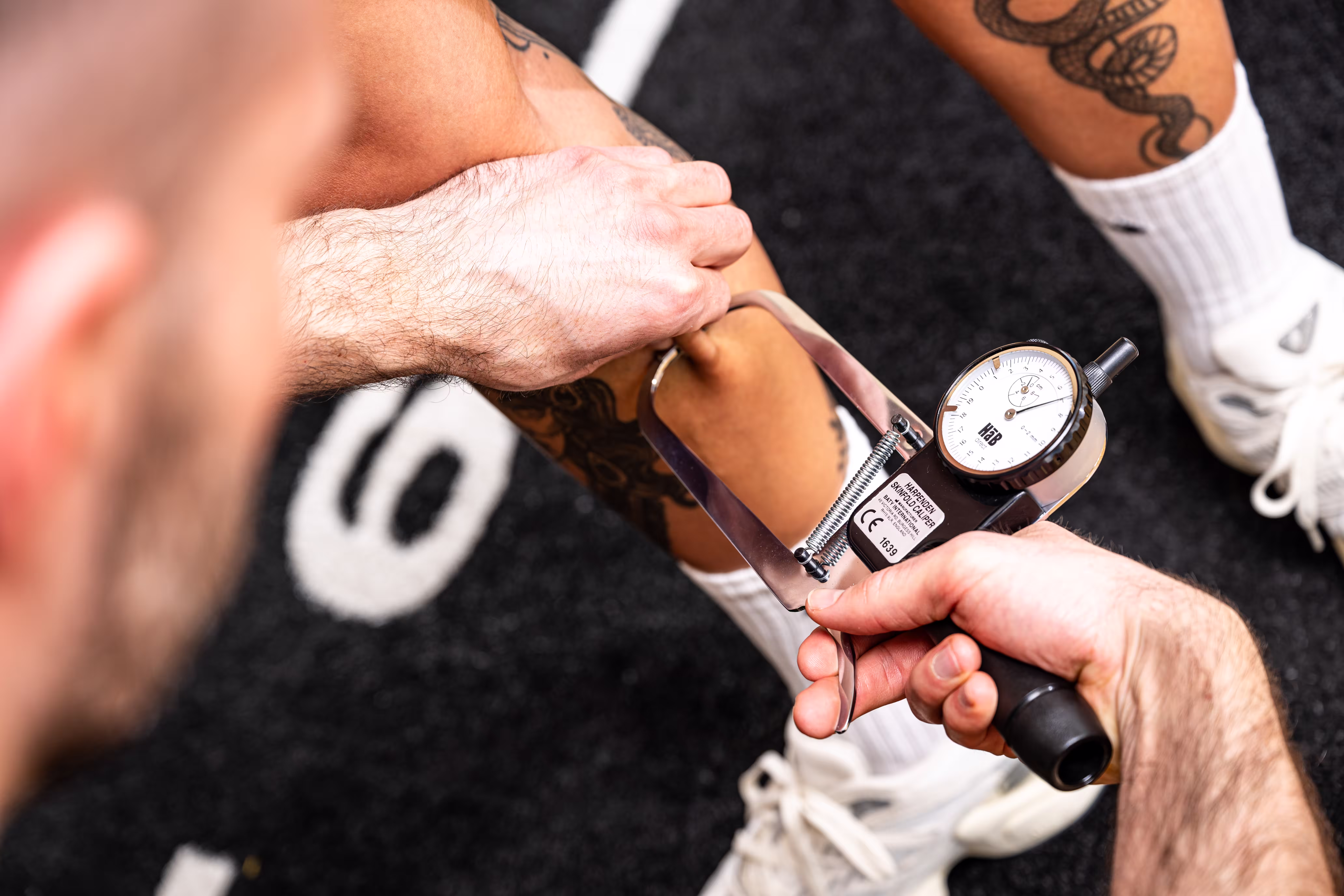 Peter Bischof misst den Fettanteil an der Wade einer Klientin mit einem Caliper