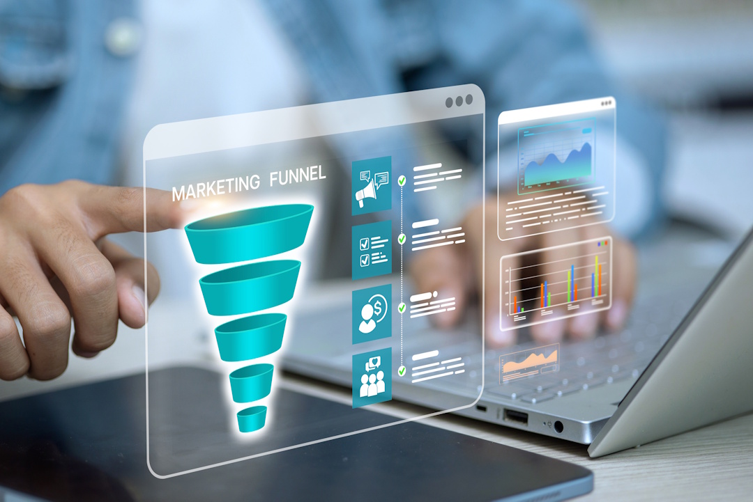 Person interacting with digital marketing funnel and data charts on a transparent screen above a laptop.