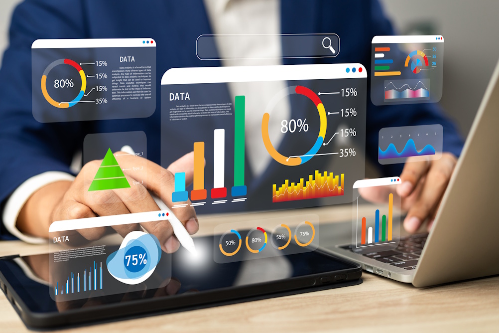 Person interacting with data visualization charts and graphs on digital tablets and laptops.