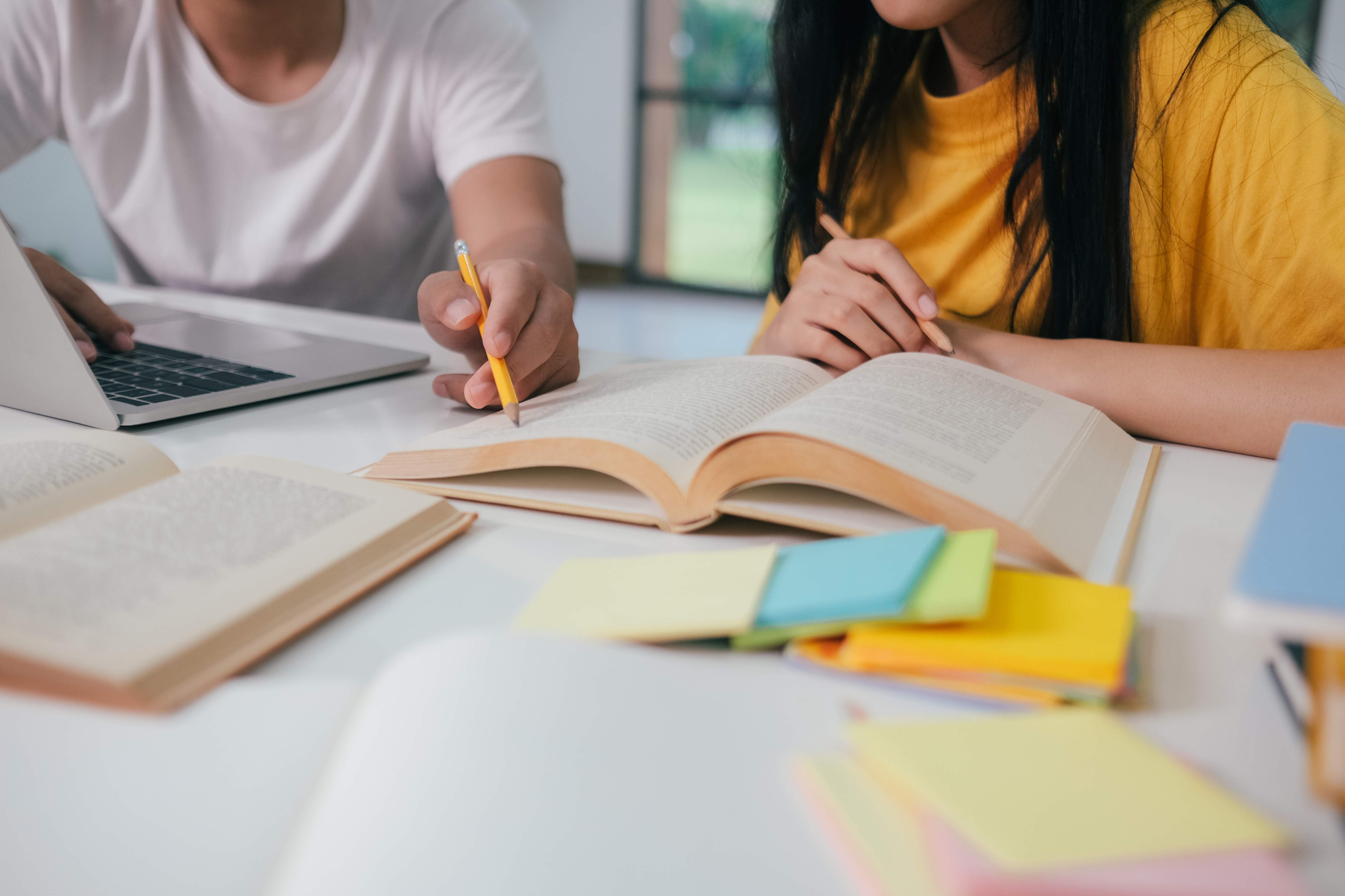 Deux enfants assis a la table font leurs devoirs