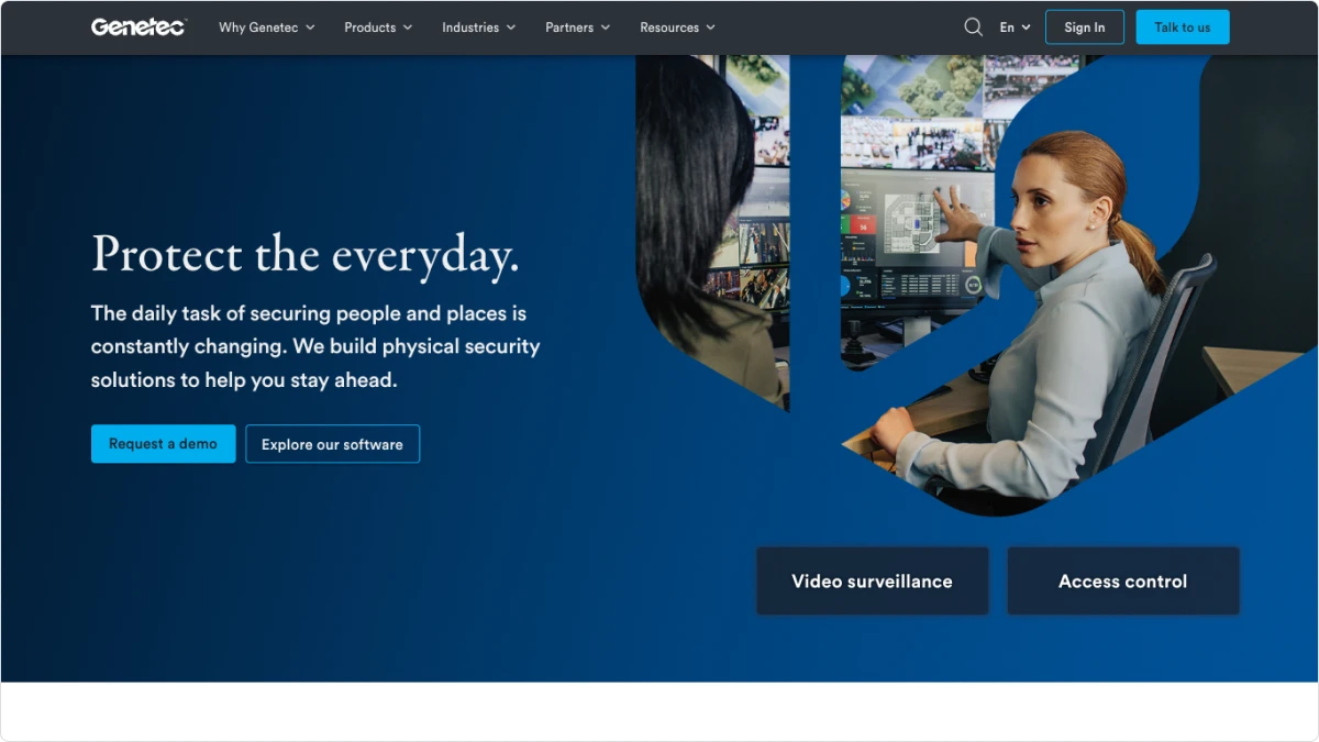 A woman pointing at a video security dashboard on a screen.