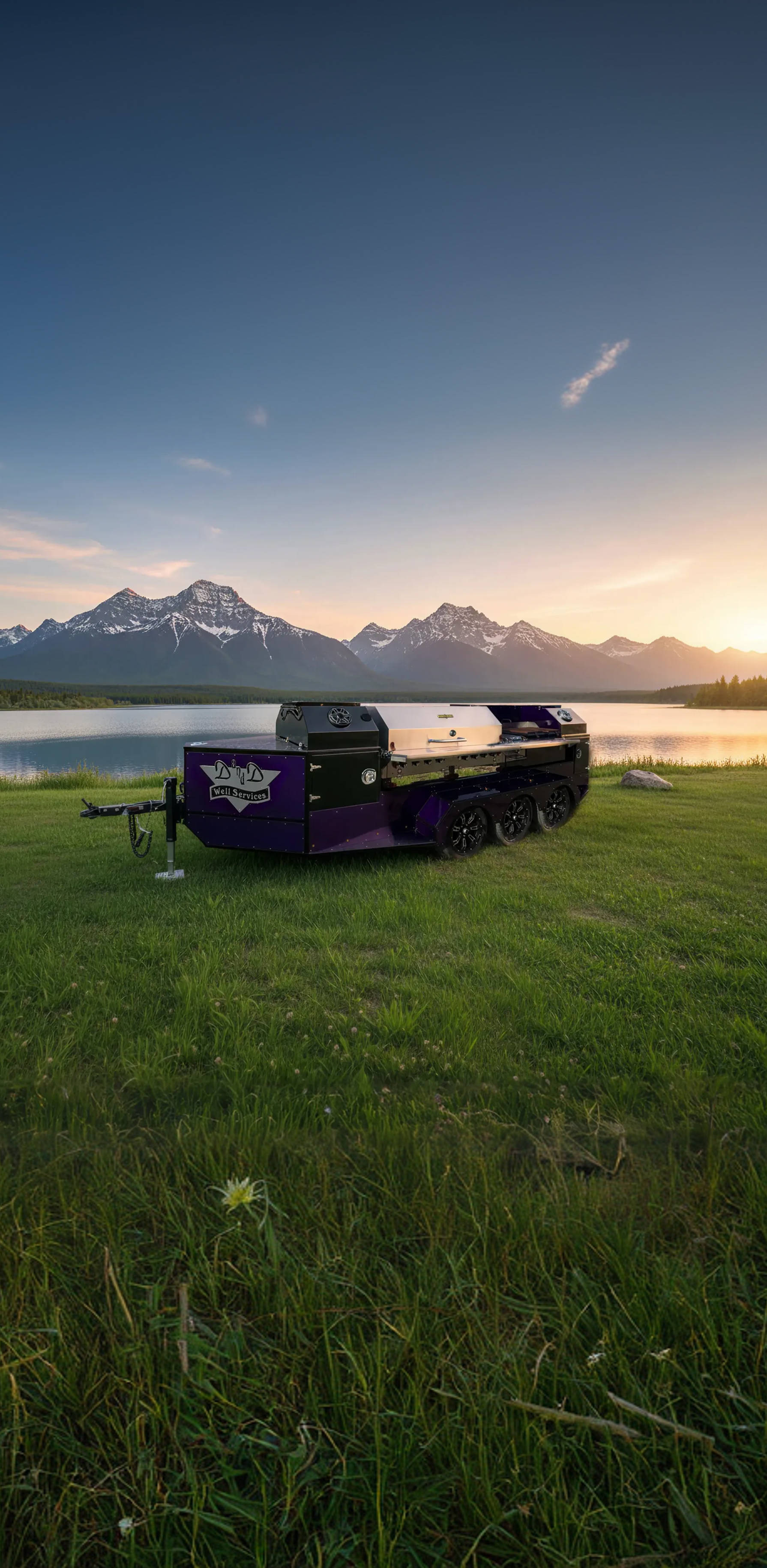 Custom BBQ Trailer made for Red Liquid Edge Oilfield Services parked on a dirt path in a forest at dusk.