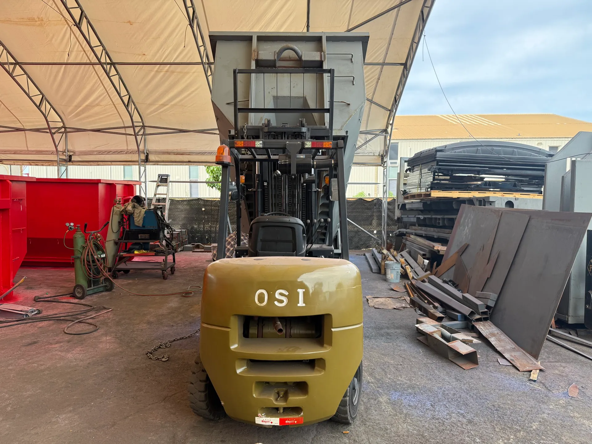 OSI diesel forklift lifting a steel container to full mast height in Hawaii