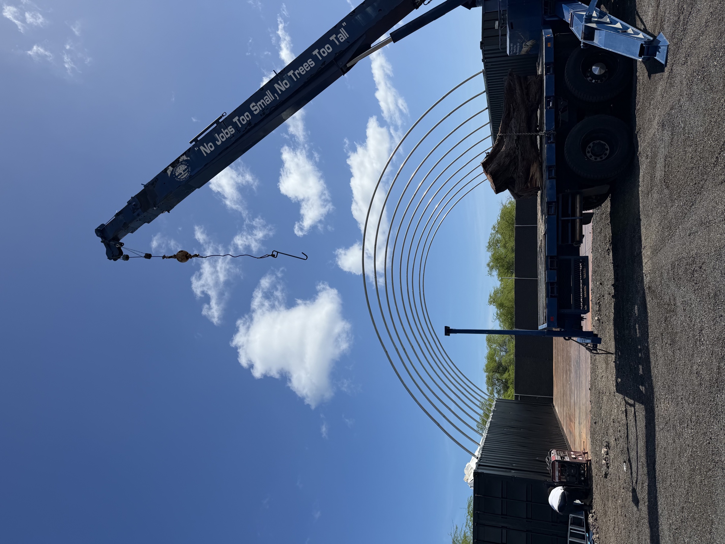 Crane setting the first arches for the container tent frame
