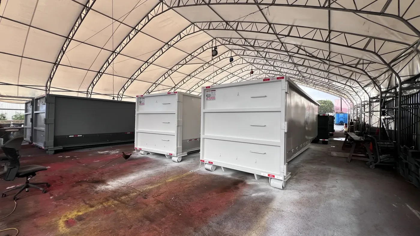 Completed roll-off dumpsters lined up ready for pickup at the HIWASTE MFG shop