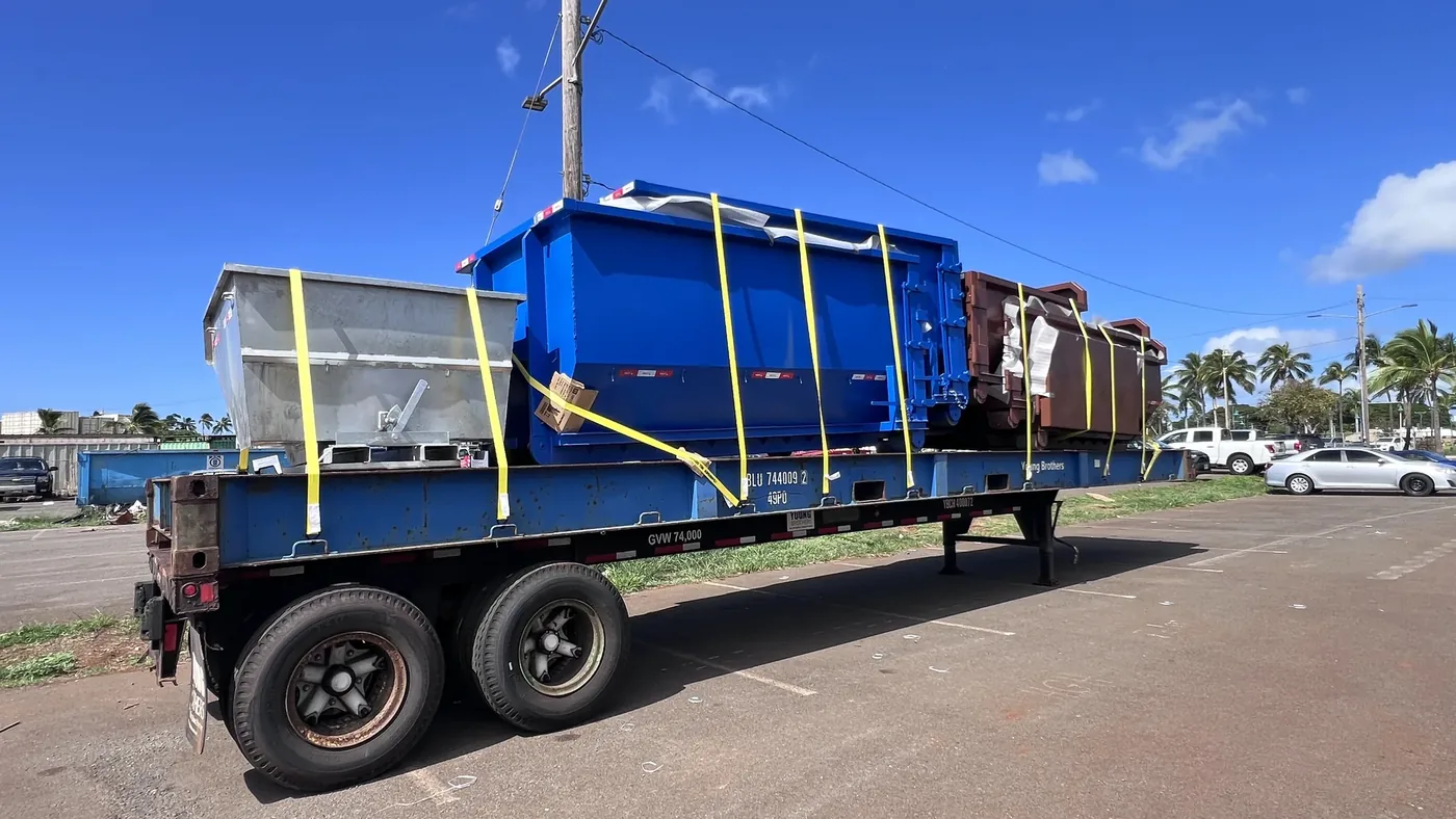 Dumpsters and self-dumping hopper staged on the shipping platform