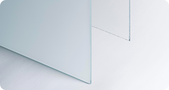 Close-up of two overlapping frosted glass panels with rounded edges on a white surface.
