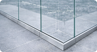 Close-up of glass panels aligned on a metal frame with technical annotations in French showing panel alignment, junction, and angle.