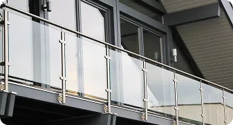 Modern building balcony with glass panels and metal railing.