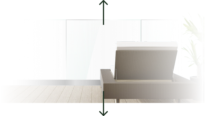 Side view of a modern wicker chair with white cushion by a large glass window and a potted plant.