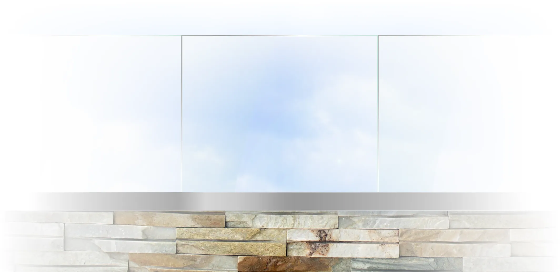 Modern minimalistic fireplace with a stone base and a reflective glass panel above it.