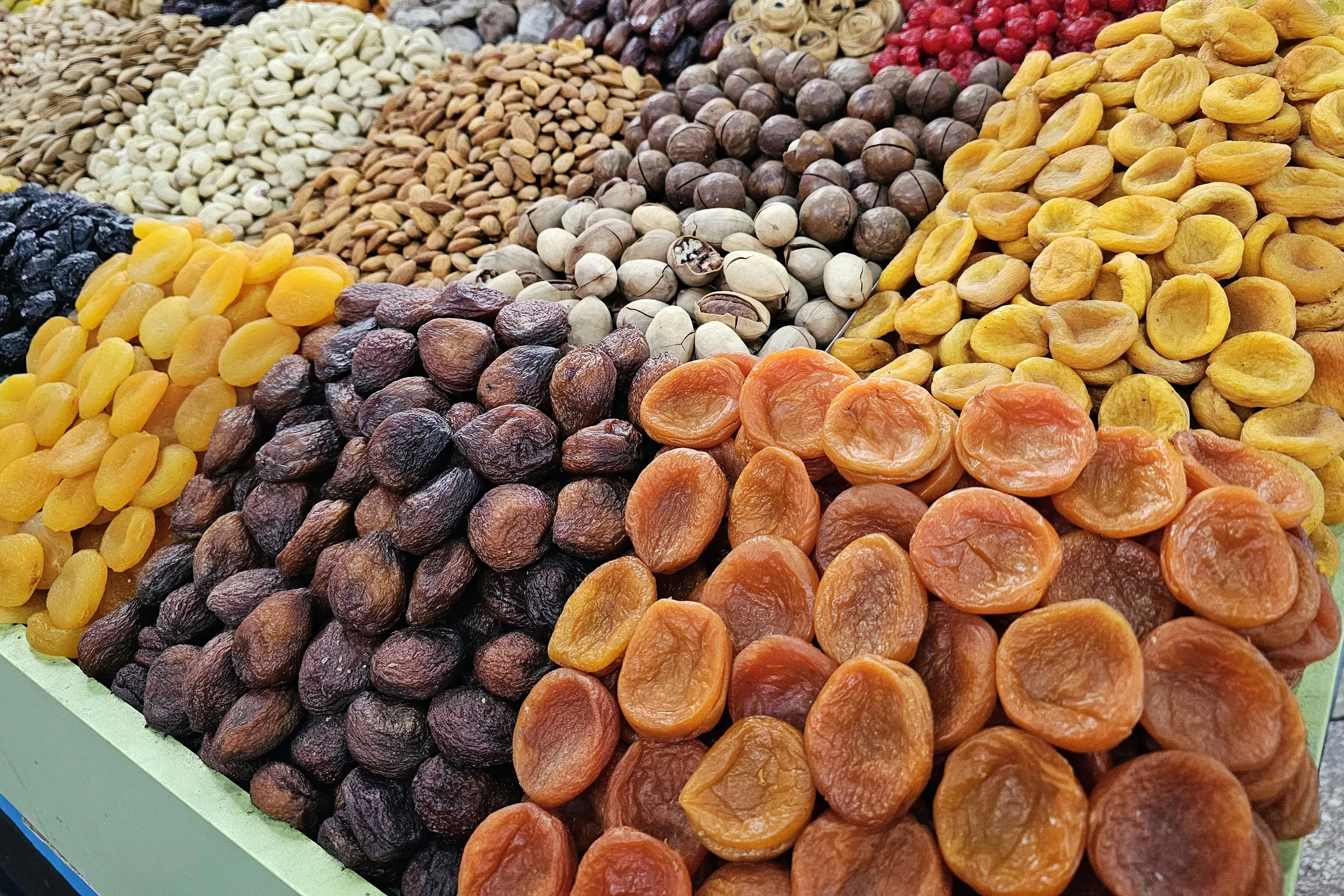 Dried apricots, mulberries and almonds sorted on a packing table