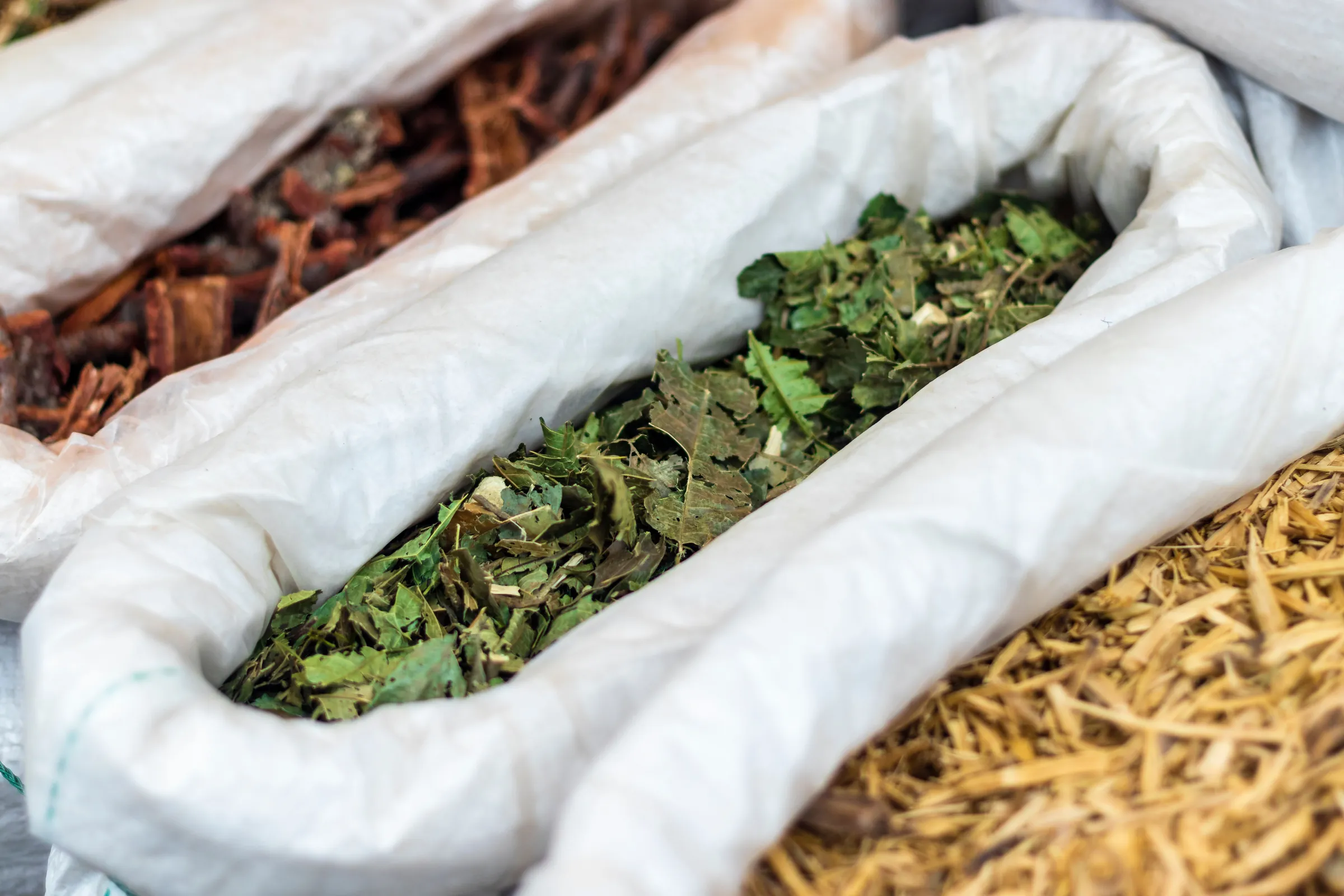 Dried licorice root and herbs in cotton sacks