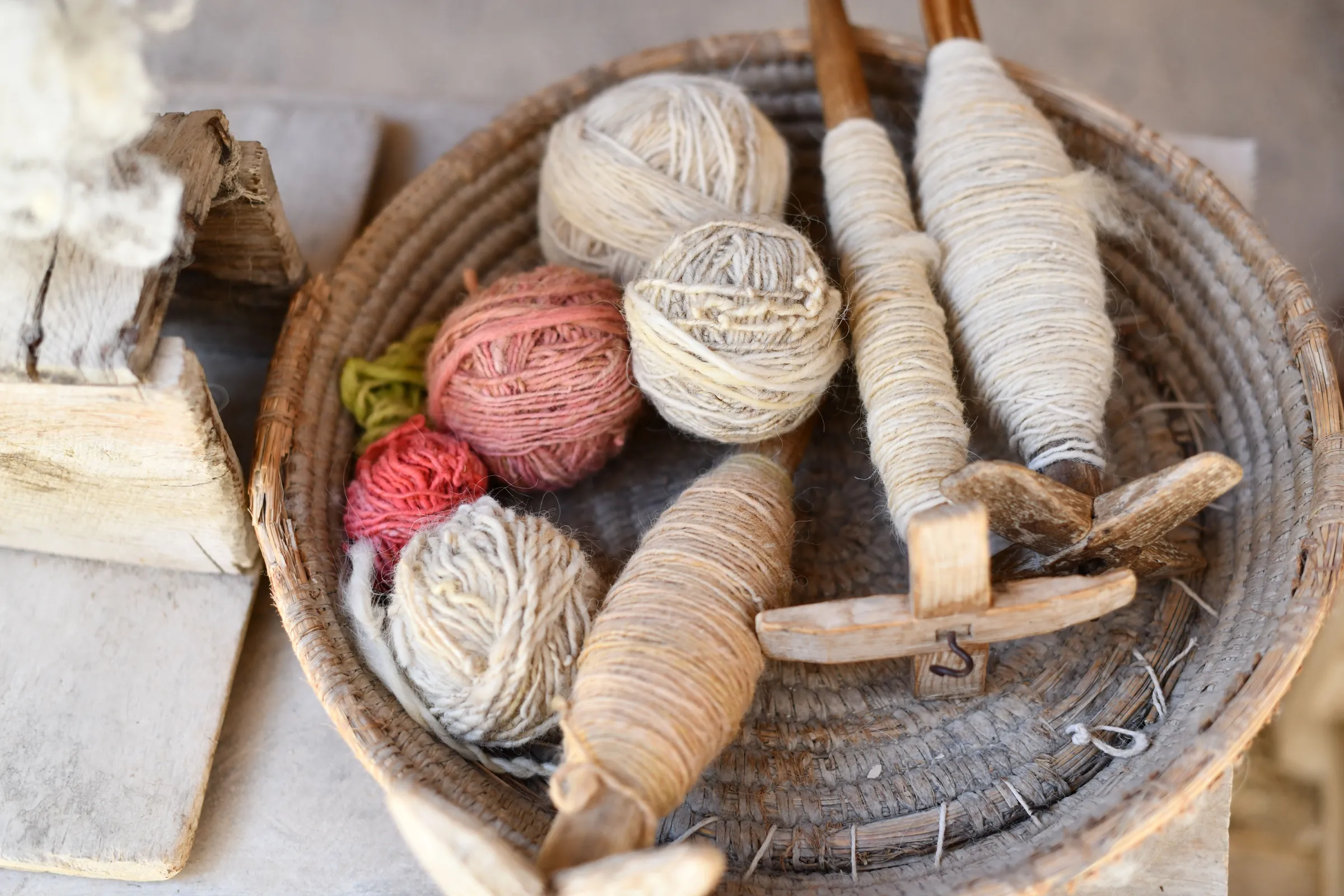Raw cashmere fiber and spun yarn on a wooden table