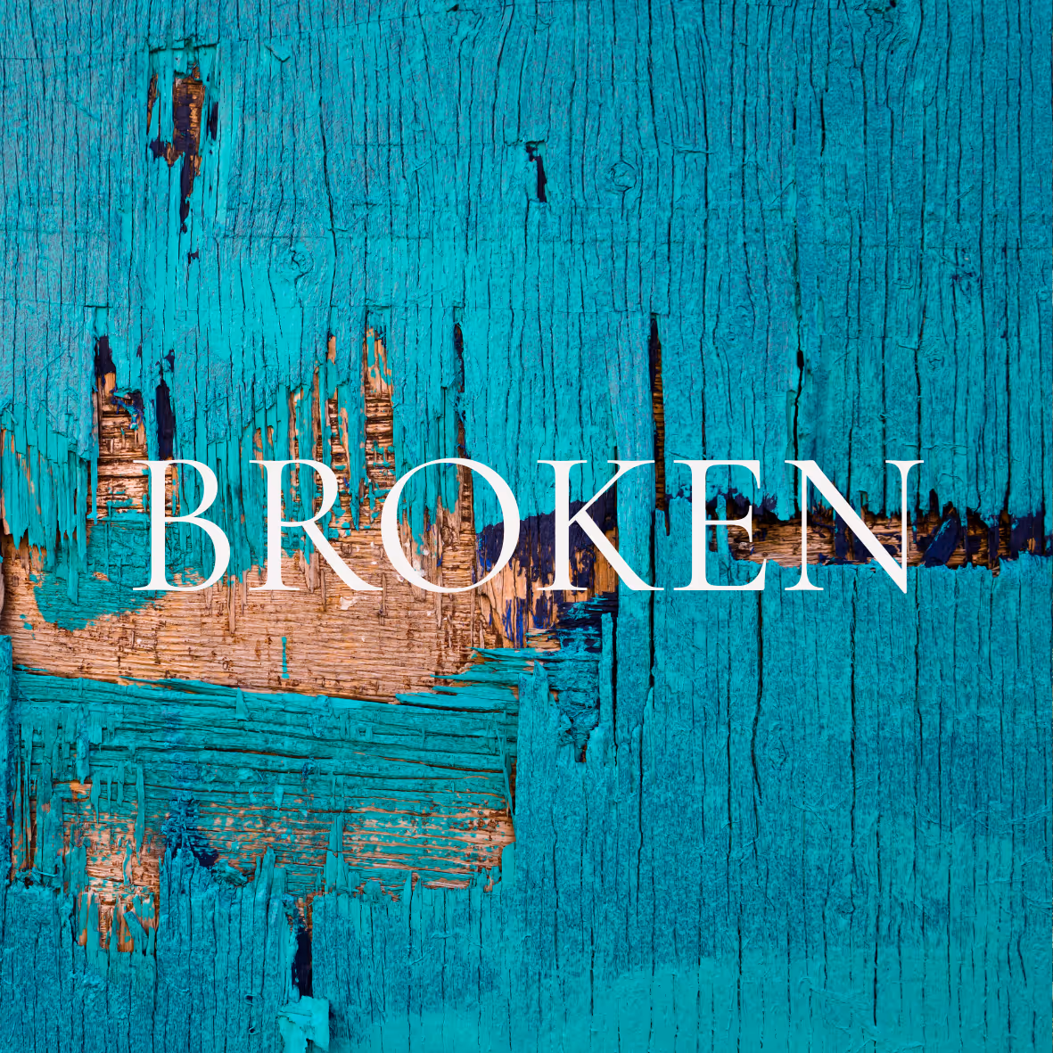 Close-up of cracked and peeling turquoise paint on wood with the word 'BROKEN' in white capital letters.