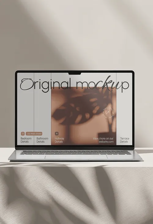 Laptop mockup on soft fabric with a reflective screen and artistic shadow overlay.