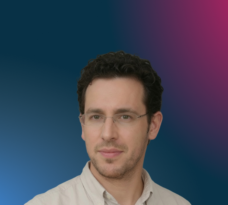 Porträt eines Mannes mit kurzen lockigen Haaren, Brille und hellbeigem Hemd vor blauem Hintergrund.