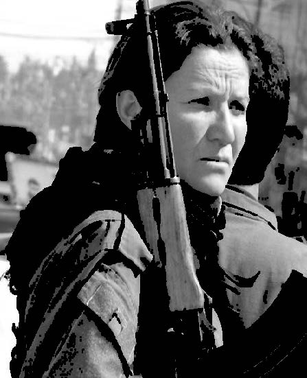 Woman looking ahead with a rifle laying on her shoulder.