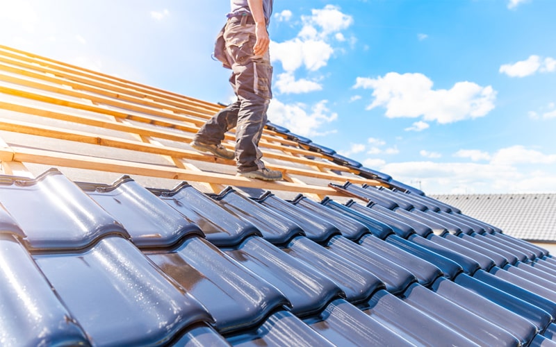 Couvreur posant des tuiles sur une toiture